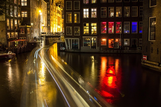 amsterdam night canal skyline with deep crimson and matte black neon overlay, abstract gaming keyboard glow accents, no people